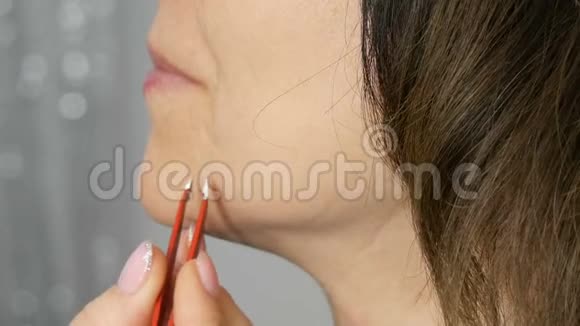 从女人脸上拔头发的专用镊子与年龄有关的皮肤变化视频的预览图