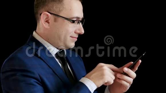 男人商人有快乐的感情和微笑一个商人正在翻阅他智能手机上的新闻视频的预览图