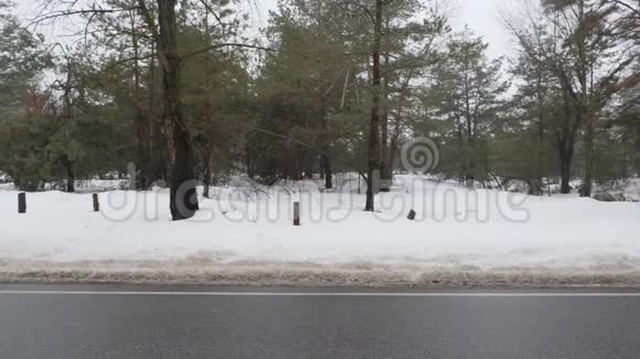 年轻迷人的白种人女孩在冬天带着耳机在雪地公园跑步侧射慢动作视频的预览图