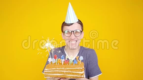 生日快乐带着橙色背景蛋糕的年轻滑稽男子视频的预览图