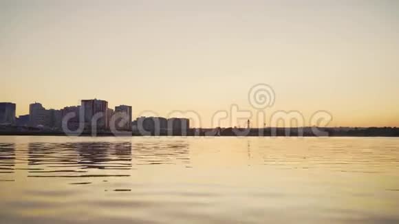 日落时分的城市日落时分在城市背景上的摩托艇靠近摄像机的水视频的预览图