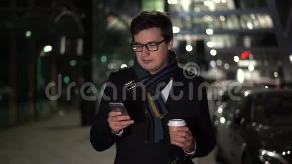 晚上男人端着咖啡走着微笑着看着留言视频的预览图