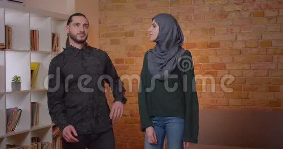 一对年轻有魅力的阿拉伯夫妇的房子规划和在一间新买的室内公寓中安顿下来的特写镜头视频的预览图