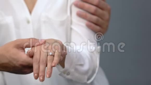 有爱的一对夫妇把订婚戒指戴在女朋友的手指上给母亲看婚姻视频的预览图