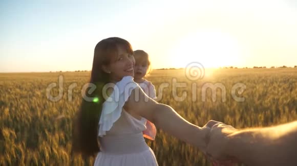 幸福的家庭携手在一片麦田里慢动作拍摄爸爸妈妈和女儿牵手旅行视频的预览图