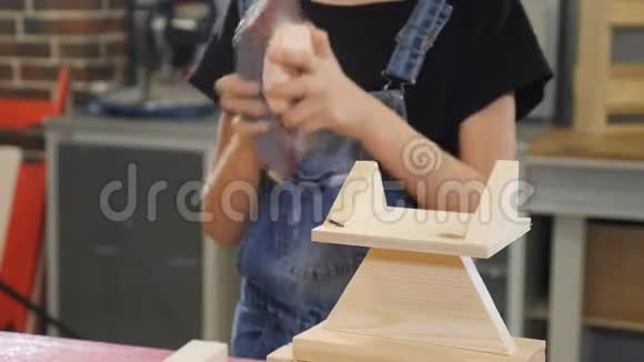 儿童木工制造十岁的女孩用磨砂布和木头工作小女孩的特写视频的预览图