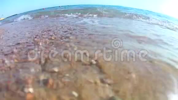 阳光明媚的一天海浪拍打着沙滩上的海浪红色的大海从下面的海岸可以看到超宽的景色视频的预览图