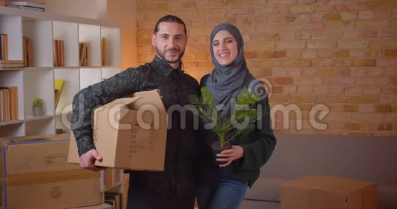 一对年轻快乐的穆斯林夫妇在一间新买的公寓里看着摄像机的特写照片视频的预览图