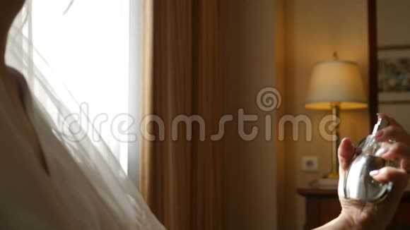 女人在婚礼当天在酒店房间用香水涂在脖子上无名女子慢动作喷香视频的预览图