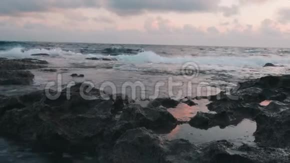 靠近大海岩靠近岩石海岸巨浪撞击岩石海上泡沫撞击岩石海岸美丽的海洋视频的预览图