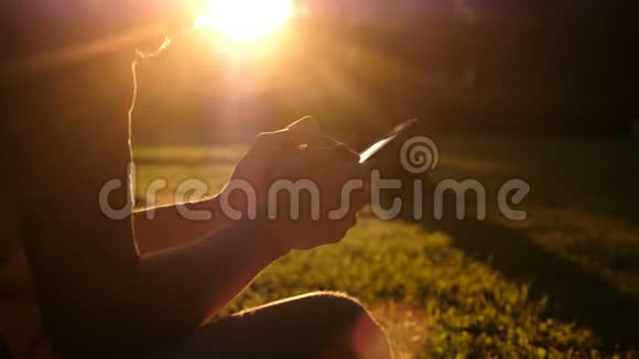 夏天日落时分男人在公园里使用智能手机科技休闲理念视频的预览图