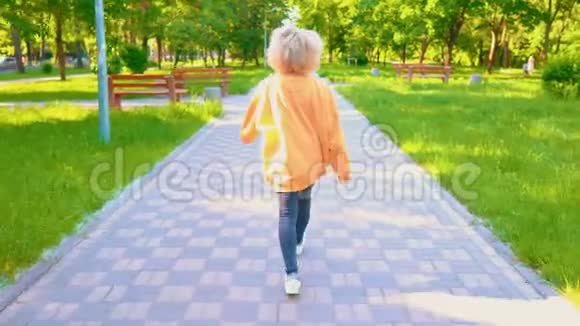 一位留着金色卷发的女士在公园散步视频的预览图