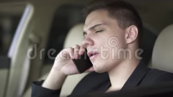 年轻人在车里嚼口香糖和用手机说话的肖像富自信商人的休闲视频的预览图