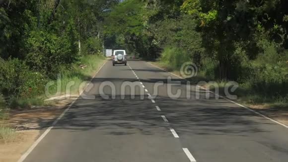 沥青路车辆行驶在树影高处视频的预览图