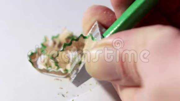 削尖一支简单的绿色铅笔用一把削刀男性手放在一个浅色的背景上视频的预览图