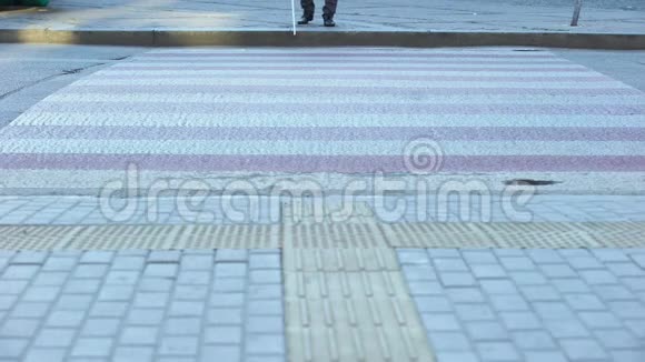 盲人用白色拐杖穿过街道用触觉瓷砖导航城市视频的预览图