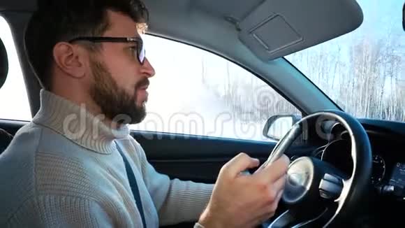 冬天一个人在城市之间的公路上开车他在智能手机上写了一条信息注意力不集中视频的预览图