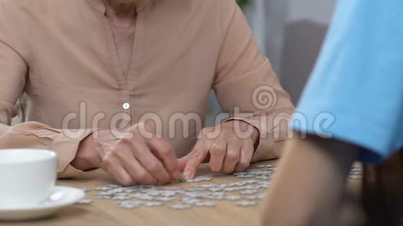 老年妇女做拼图年轻女士帮忙出血后康复视频的预览图