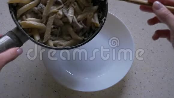 一只雌性手在盘子上用奶酪和蘑菇传播意大利面一道美味的菜视频的预览图