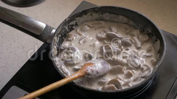 一只雌性手在蘑菇中加入意大利面这些意大利面是在平底锅里煎的视频的预览图