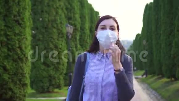 女孩从脸上摘下一个医疗面罩深深地吸入公园里的空气视频的预览图