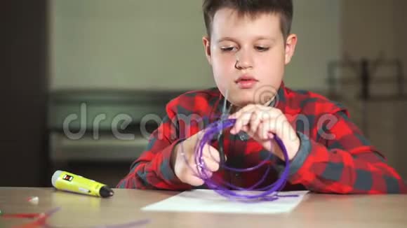 一个穿格子衬衫的十几岁男孩剪下一块ABS塑料作为3D笔视频的预览图