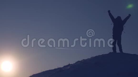 征服山峰的人站在高高的雪山上在夕阳下挥动双手为胜利而欢欣视频的预览图