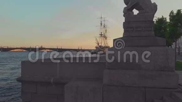 俄罗斯圣彼得堡全景彼得罗夫斯卡娅堤一尊狮子雕像和一艘帆船护卫舰视频的预览图