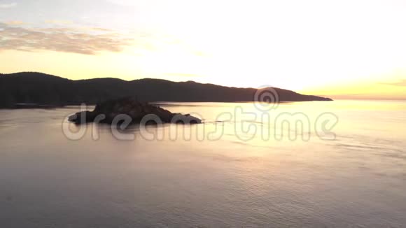 空中日出无人机拍摄温哥华岛东侧崎岖海岸线的画面视频的预览图