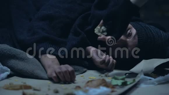 为躺在地上的饥饿无家可归的妇女提供面包的人贫穷视频的预览图