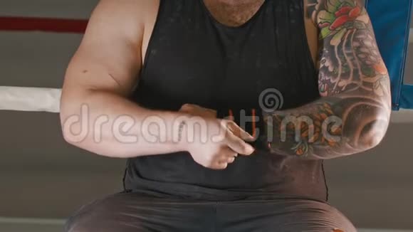 一个肌肉发达的人用弹力绷带包扎手腕视频的预览图