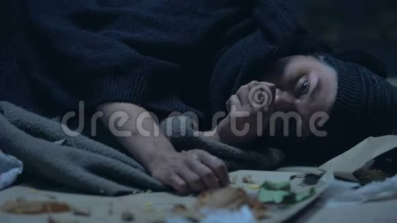 饥肠辘辘的无家可归的人躺在街上吃着最后一块馅饼视频的预览图