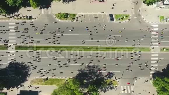 自行车赛中被骑自行车的人挤在城市道路上的高空向下拍摄视频的预览图