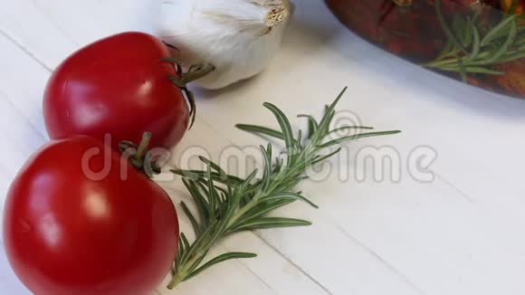 桌子上有西红柿迷迭香和大蒜在一罐干番茄附近香料和橄榄油加入其中视频的预览图