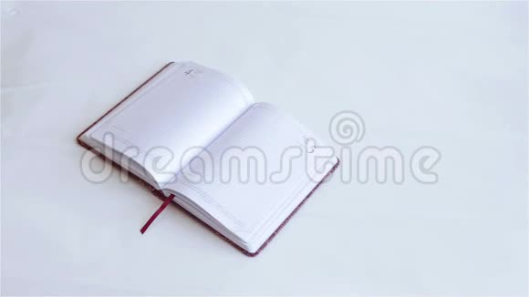 穿西装的人用钢笔在笔记本上写字视频的预览图