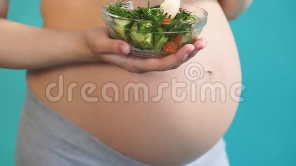 微笑着吃蔬菜沙拉的孕妇怀孕健康食品视频的预览图