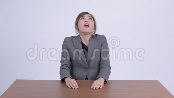 年轻有压力的亚洲女商人在办公桌旁竖起大拇指视频的预览图
