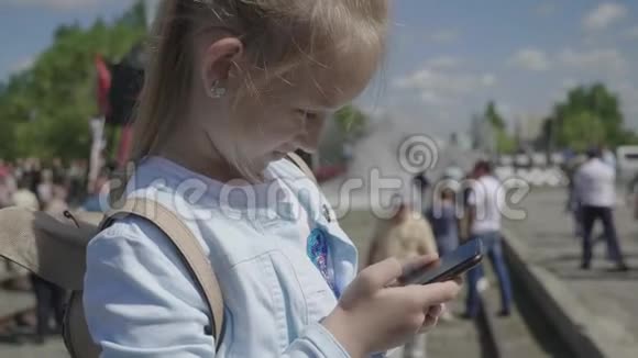小女孩在火车站等她的智能手机视频的预览图