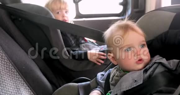 坐在汽车后座的可爱女孩和男孩视频的预览图