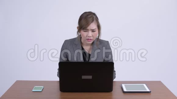 年轻认真的亚洲女商人一边工作一边思考着笔记本电脑视频的预览图