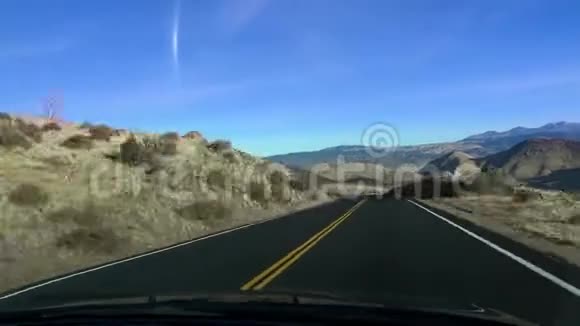 沿着沙漠之路的中心行驶五彩缤纷的蓝天视频的预览图