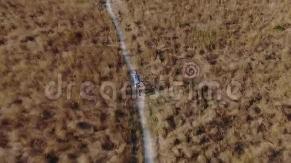 一个骑自行车的人骑着自行车在干草丛中穿过公园独单车轻出行的概念Drun射击视频的预览图