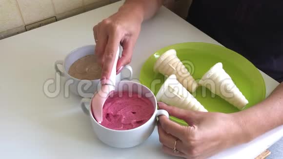 一个女人把草莓冰淇淋装满了喇叭用冰淇淋勺桌子上放着草莓和香蕉的容器视频的预览图