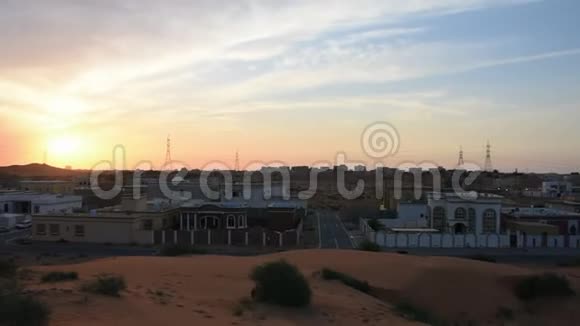 阿拉伯联合酋长国哈伊马角的沙漠上太阳落下时居民区的全景视频的预览图