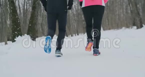 两个跑步者穿着运动鞋在公园冬天跑步的脚的特写已婚夫妇参加体育活动视频的预览图