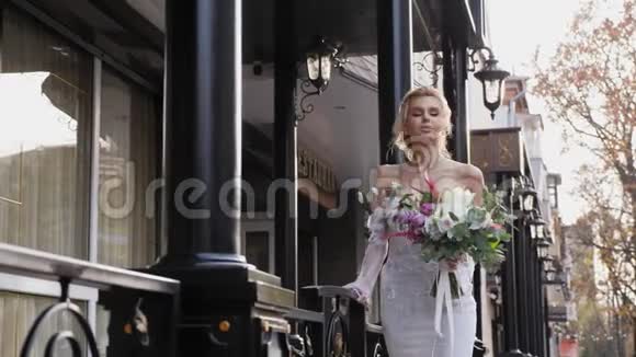 新娘在街上捧着一束五颜六色的婚礼花束视频的预览图