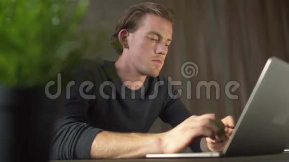 愤怒和沮丧的英俊的商人在笔记本电脑上打字英俊的商人在笔记本上发短信视频的预览图