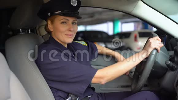 女警察身穿制服坐在巡逻车上对着镜头微笑值班视频的预览图