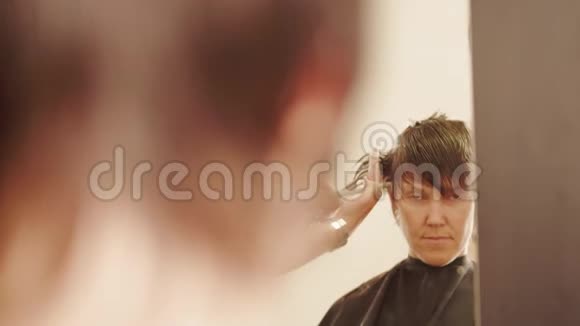 女人照镜子理发店理发视频的预览图