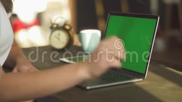 用绿色屏幕在笔记本电脑上打字的女性手的特写镜头使用绿色笔记本的女性视频的预览图